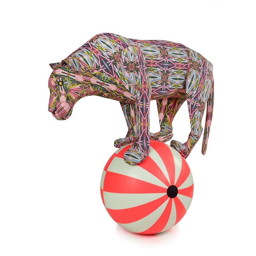 Colorful sculpture of a tiger balancing on a striped ball