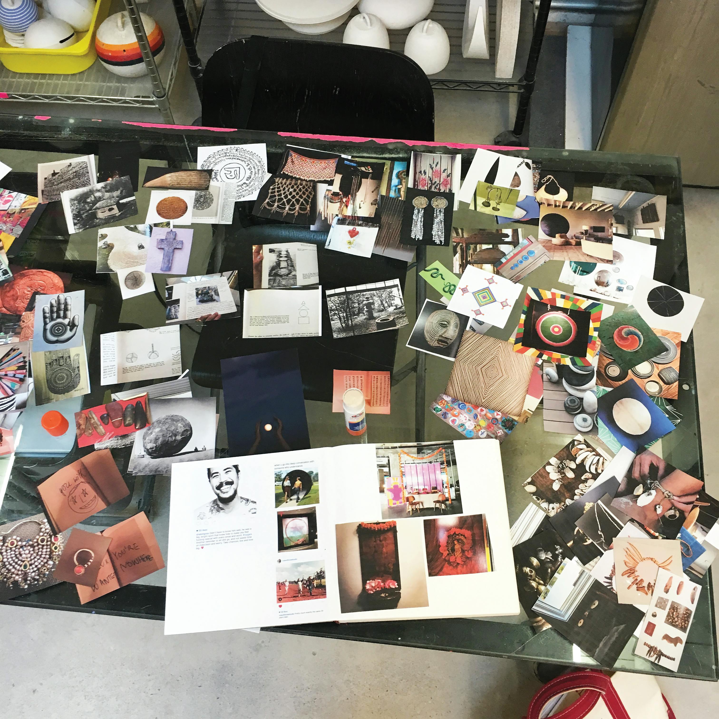 Miscellaneous photos and cutouts spread on a glass table