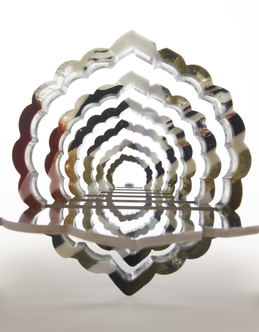 Glass sculpture with reflective cutout layers forming a tunnel