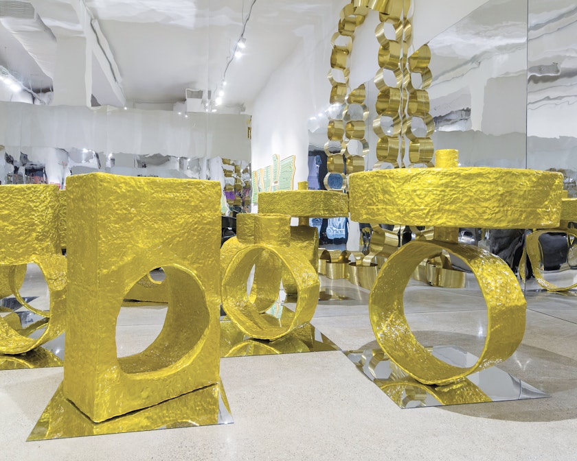 Exhibition floor with gold rings the size of statues surrounded by mirrors