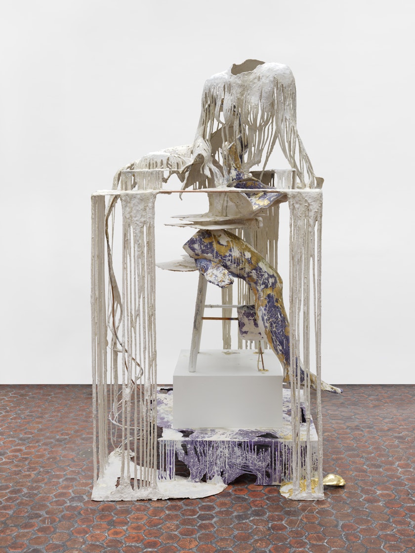 sculpture with the outline of person made from dripping plaster on a pedastal above a purple and gold mottled leg