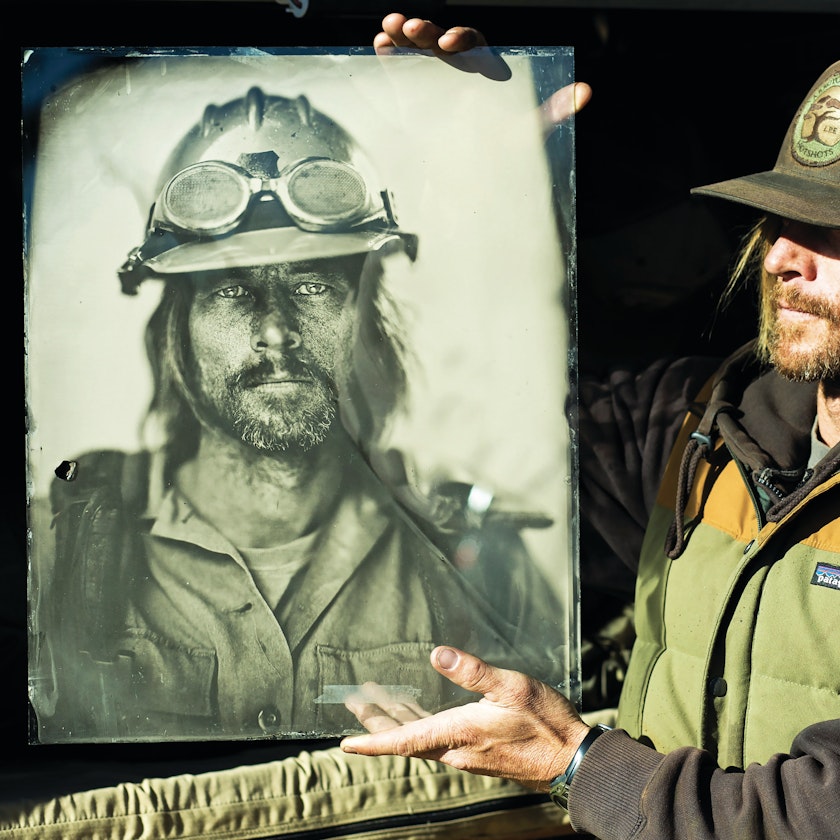 portrait of firefighter holding up an ambrotype portrait of himself