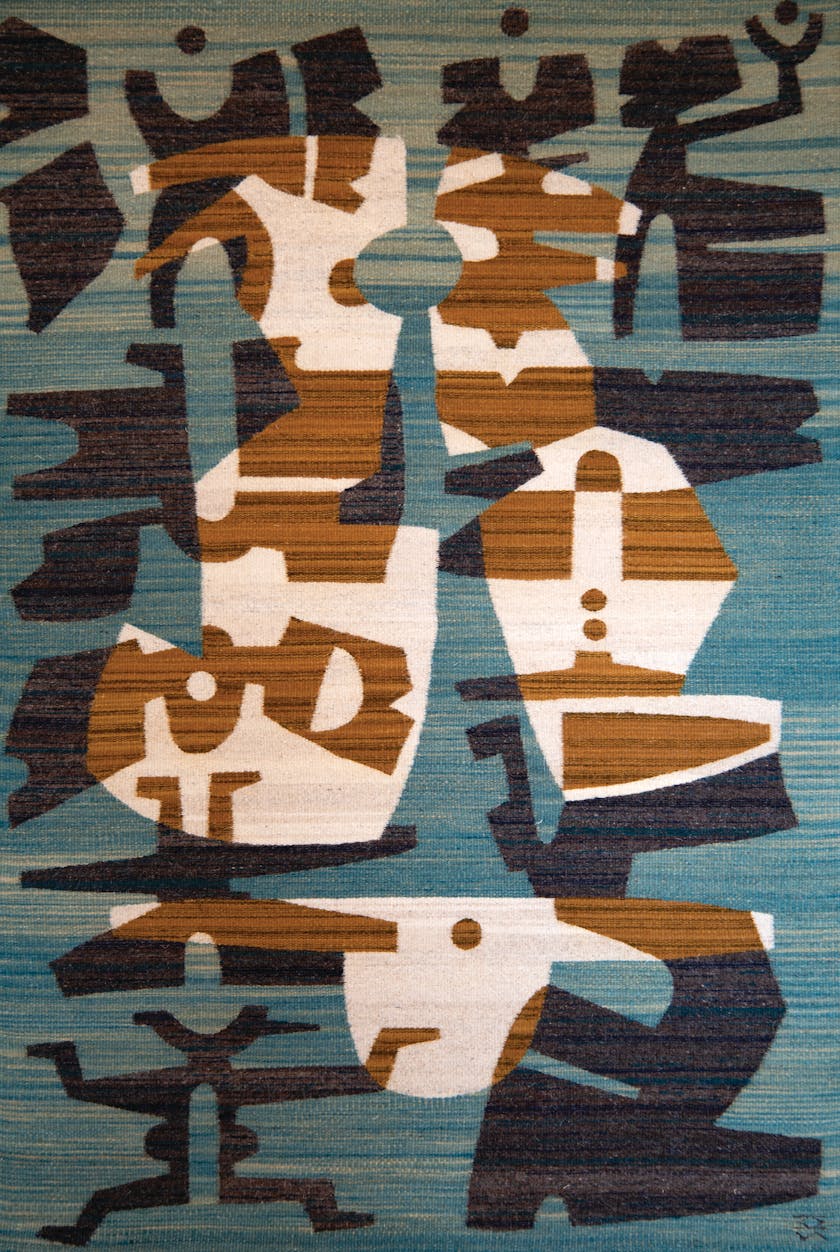 teal navy umber and cream weaving of various pictographic symbols floating in orground and background