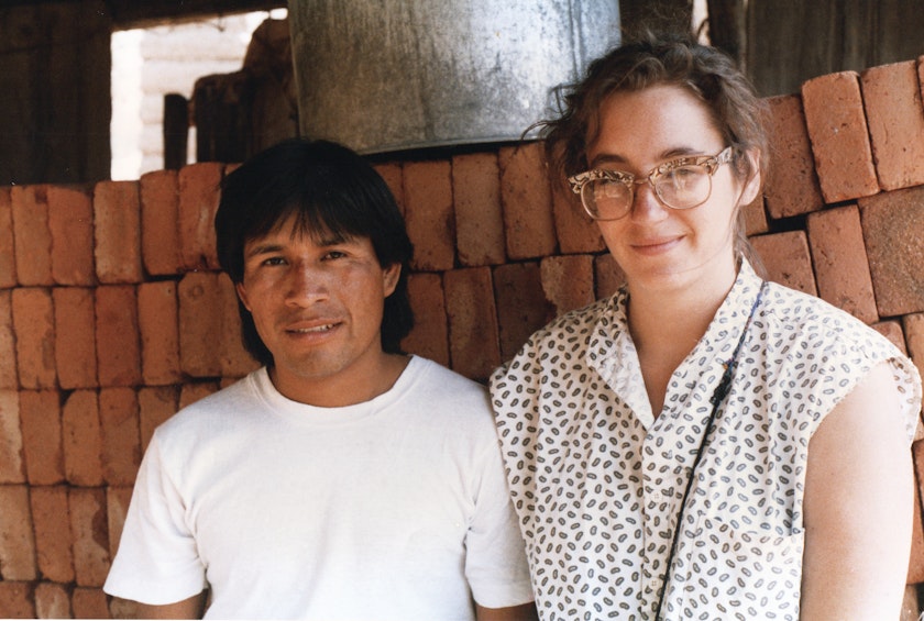 vintage portrait of a young man and woman sitting against a loosely stacked red brick wall