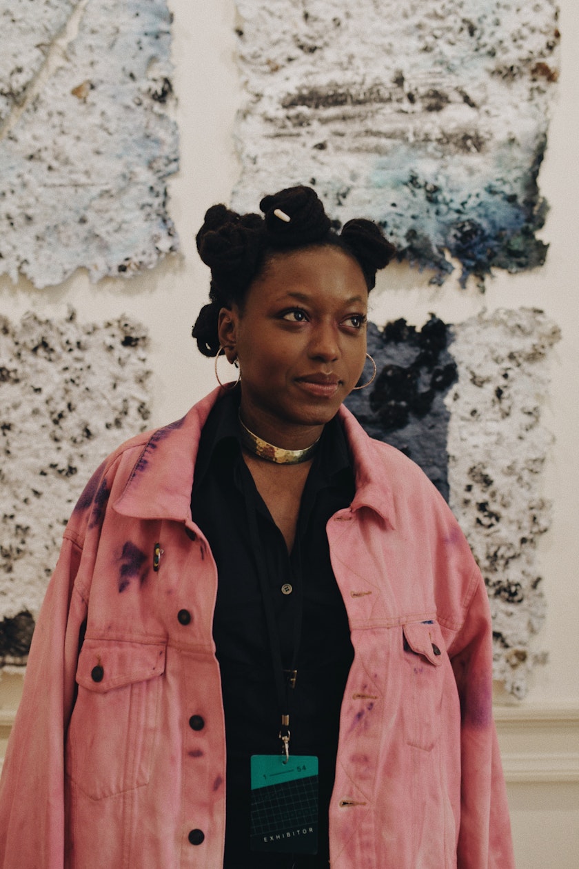 portrait of adebunmi gbadebo standing in front of wall with work from true blue series