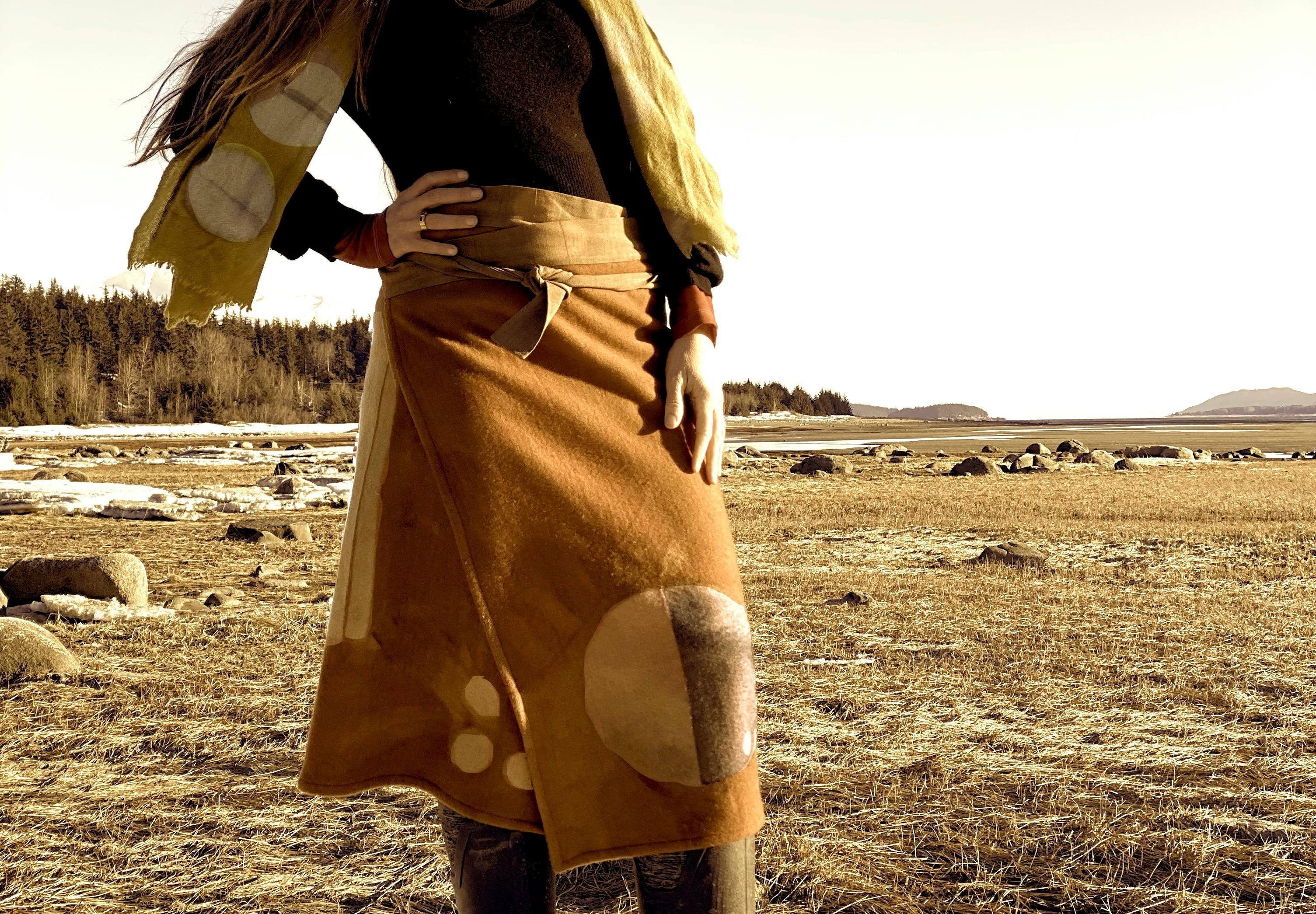model wearing hand-dyed wool garments in a tundra landscape