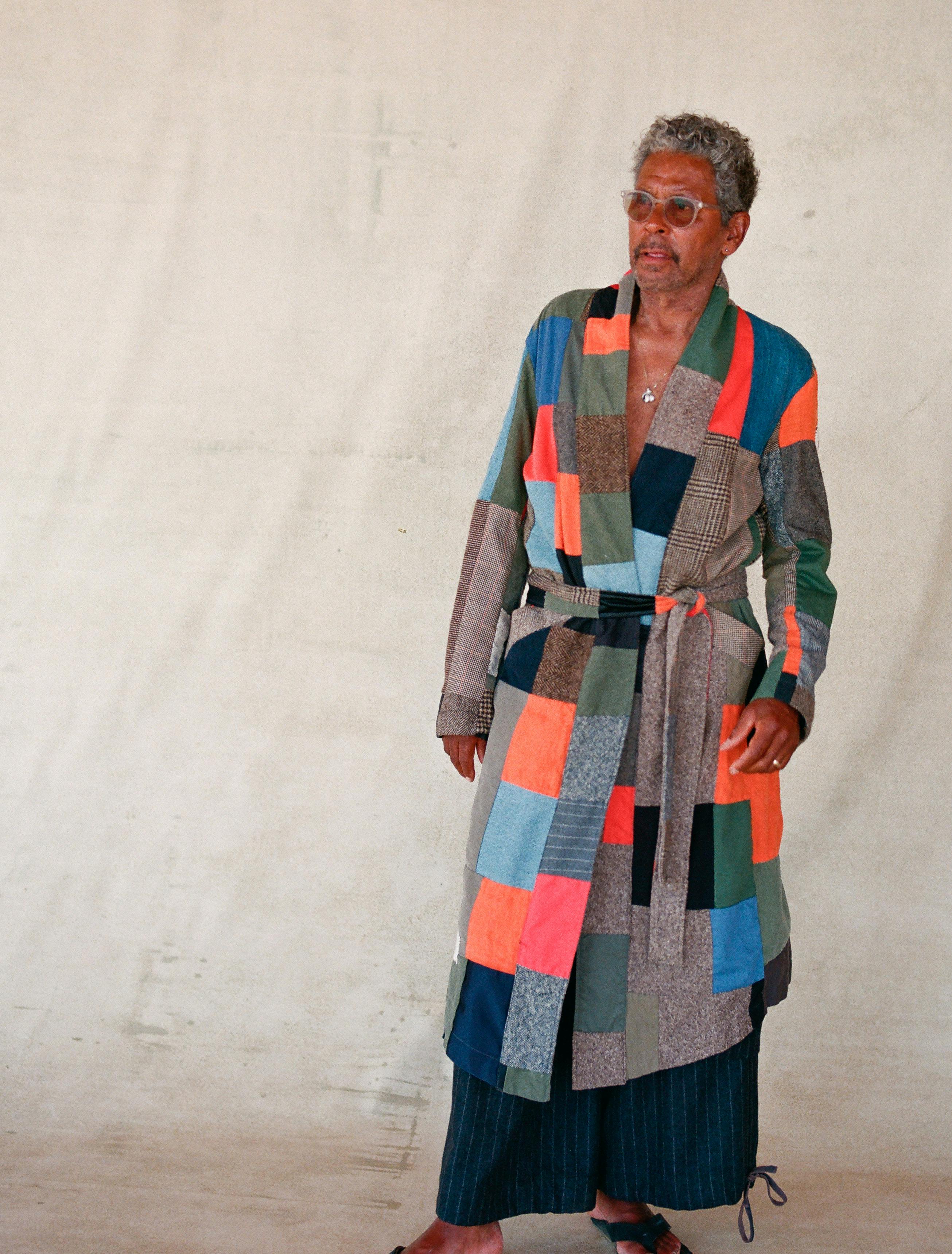 model wearing patchwork quilt robe featuring prominent orange blue and earthtones