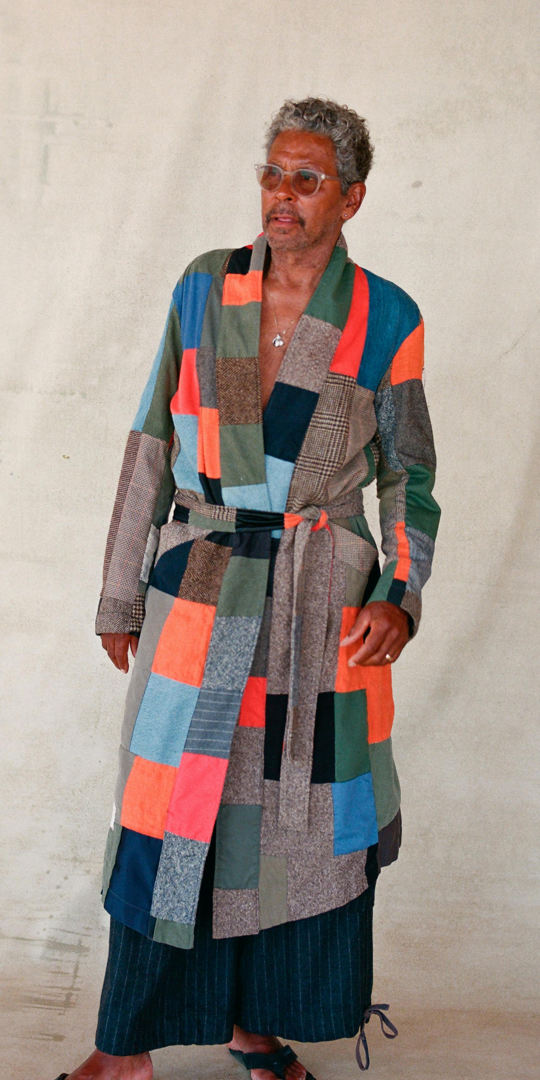 model wearing patchwork quilt robe featuring prominent orange blue and earthtones