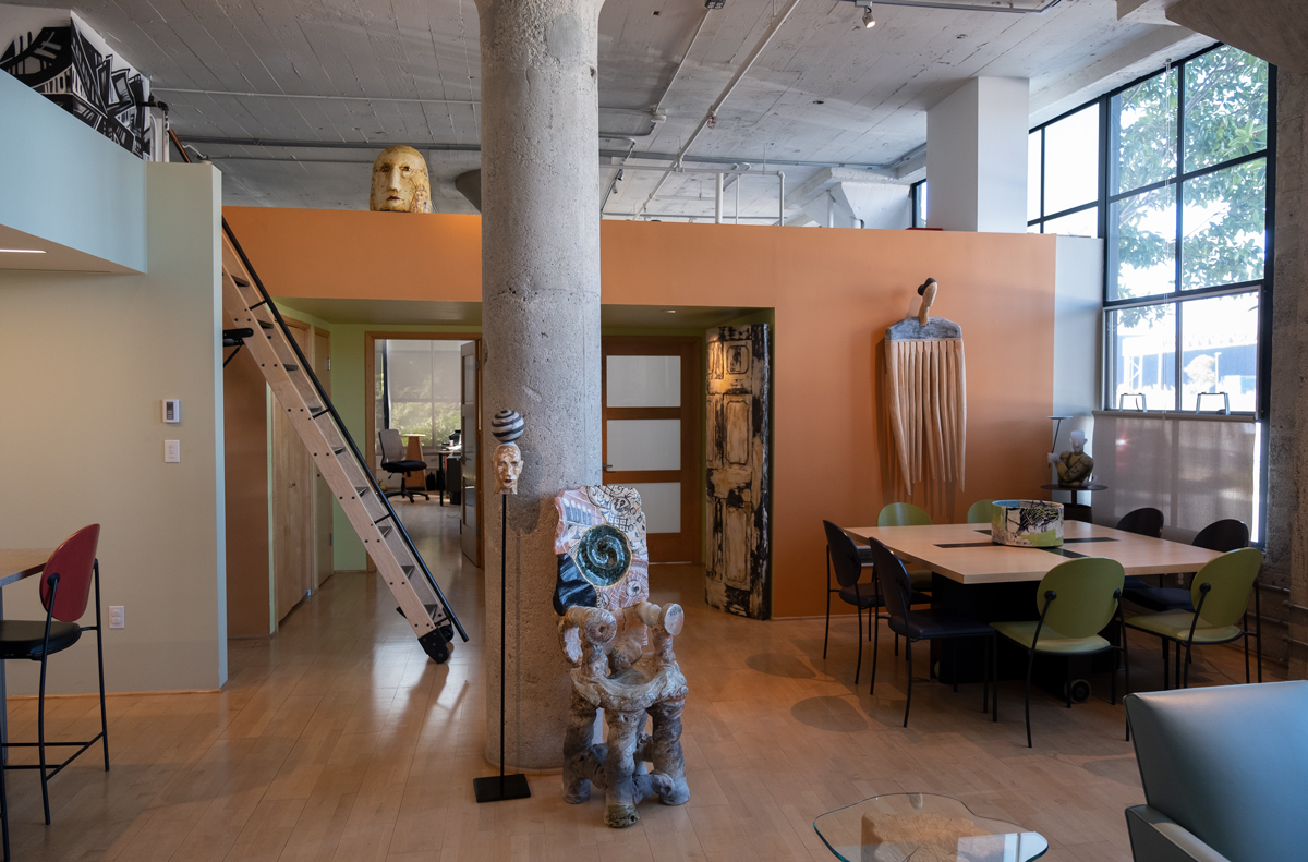 exhibition space with orange walls and green accents with various craft object on display