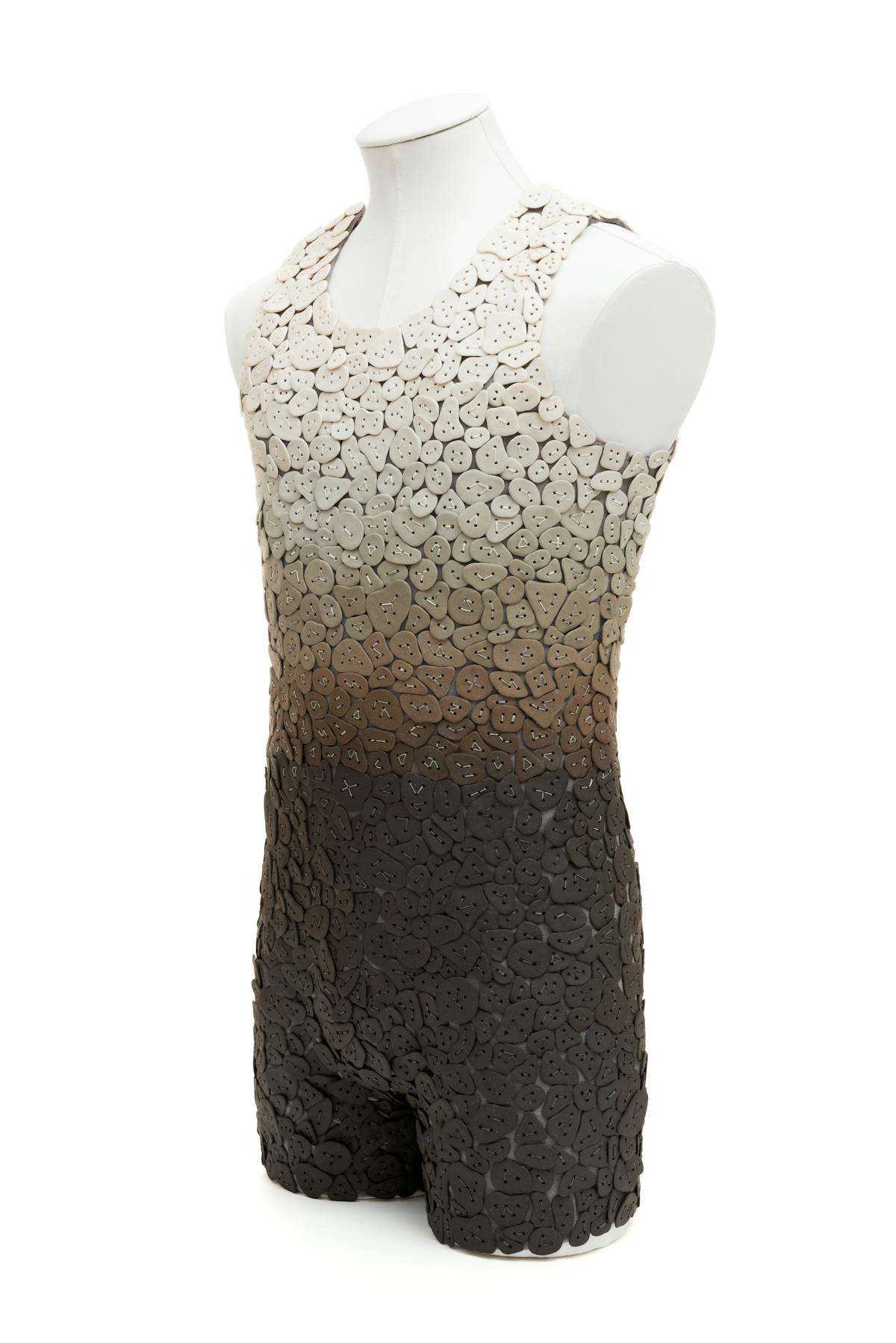 mens one-peice swimsuit made from ceramic tiles in a gradient of brown up to cream displayed on a manikin