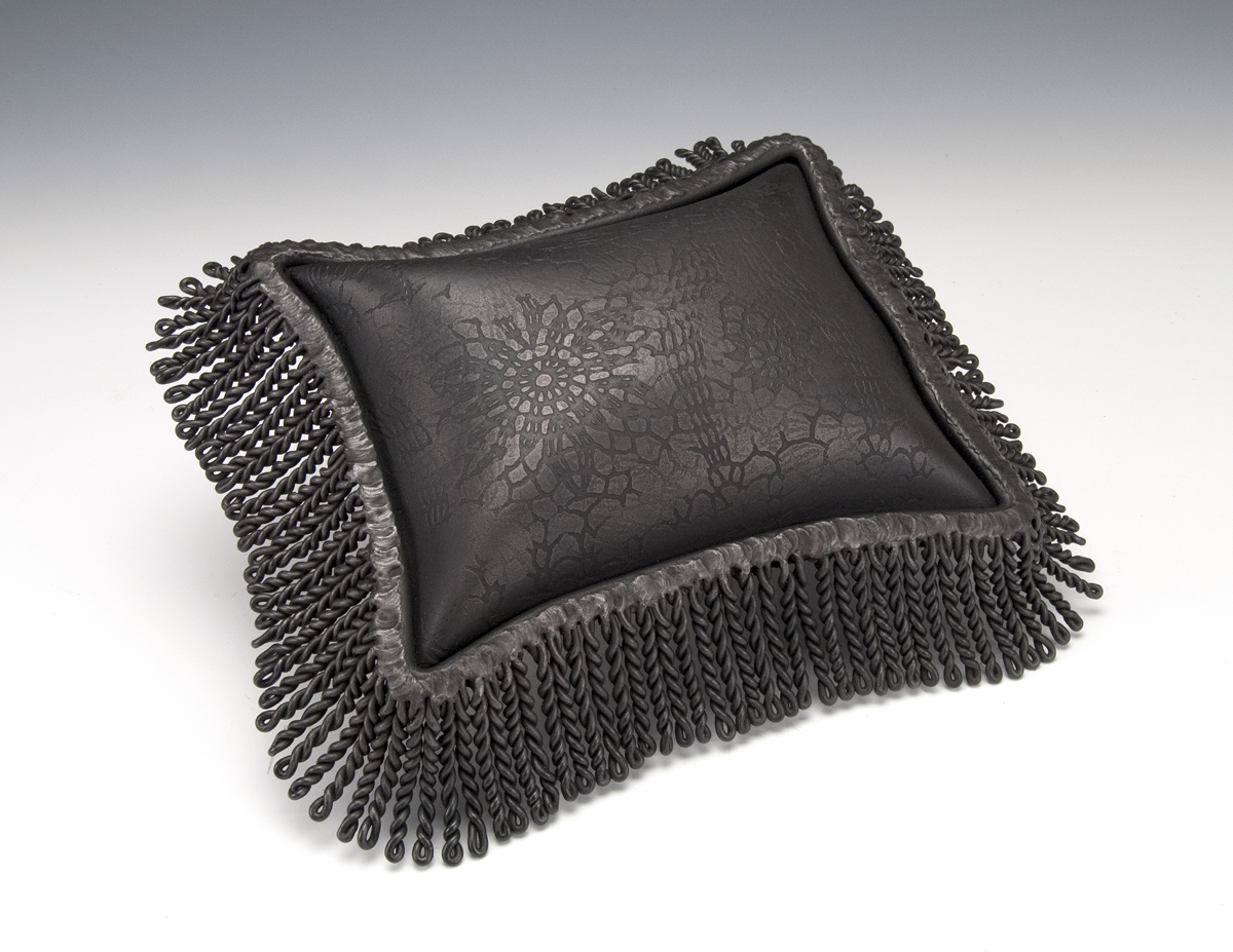 sculpture of a pillow made from black iron
