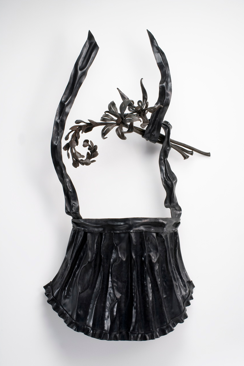 sculpture of apron and flowers made from black metal