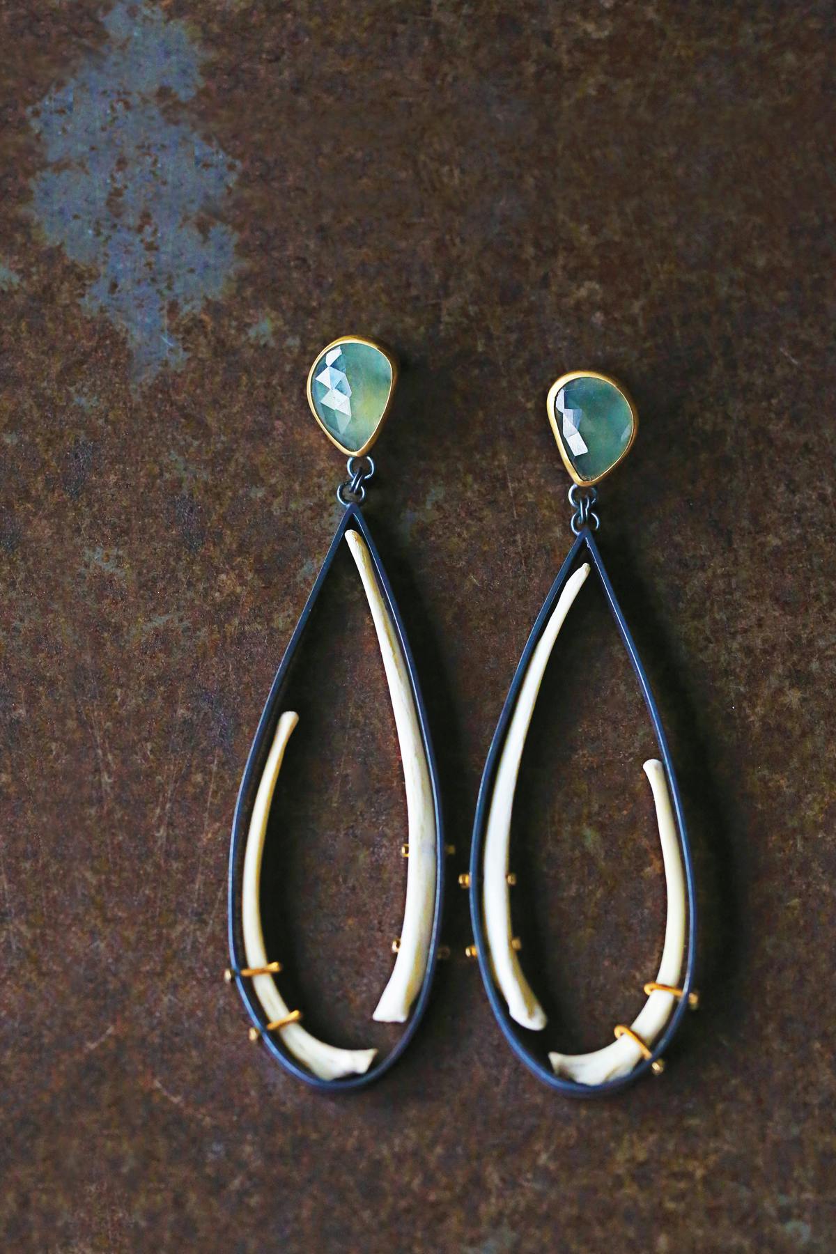 pair of tear dropped shaped earrings with teal jems and animal bones