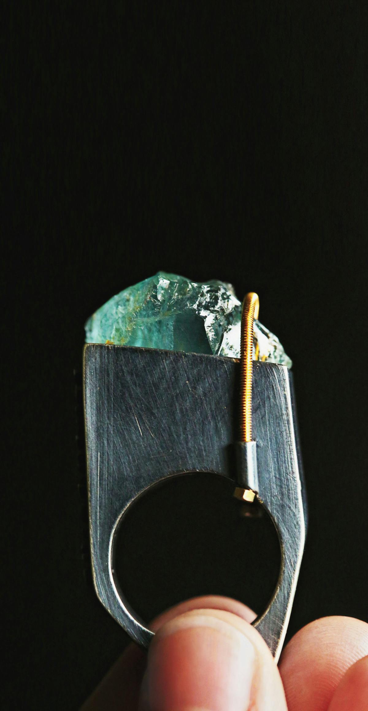 tall metal ring with aquamarine gem and bronze coiled latch