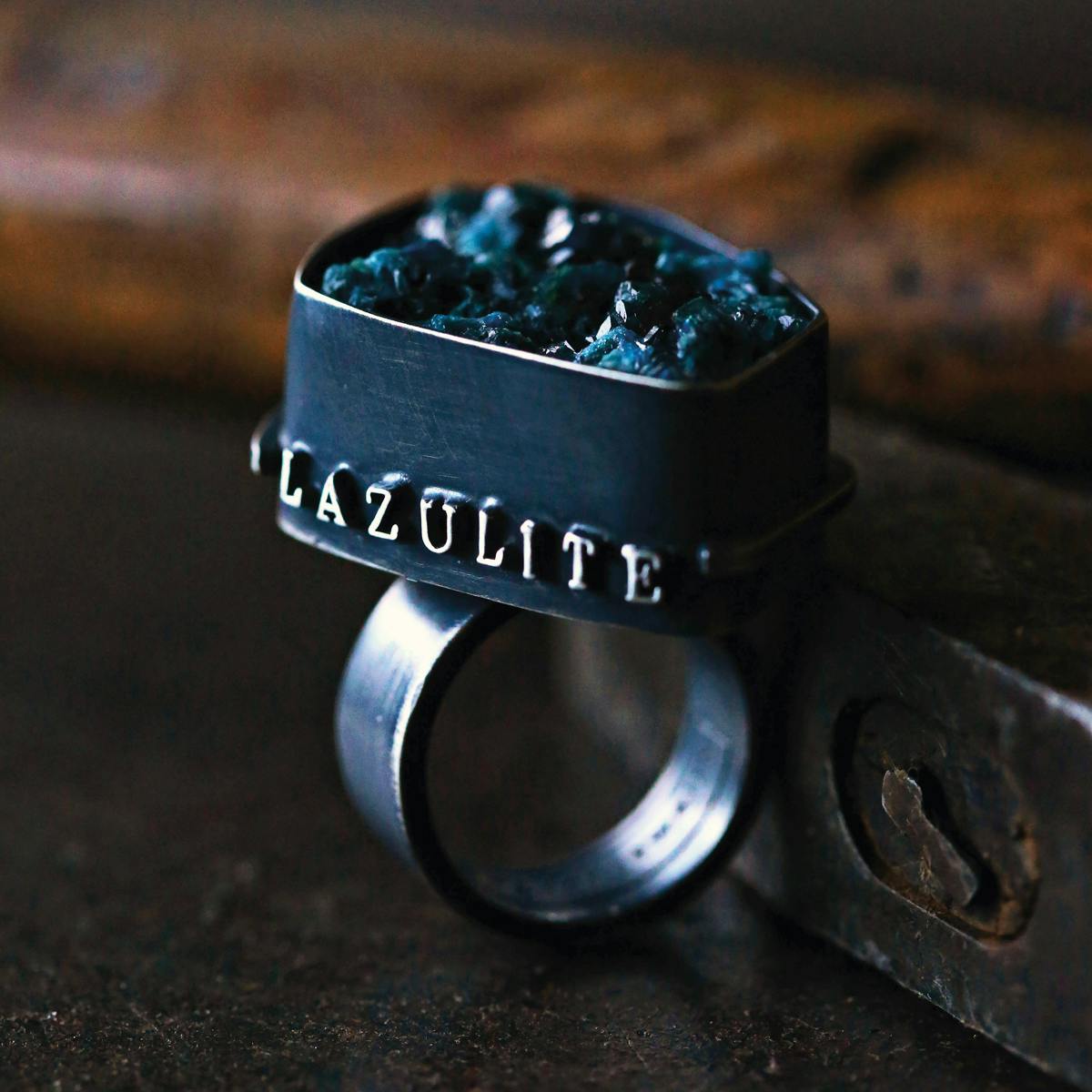 black metal ring with word lazulite and dark blue minerals