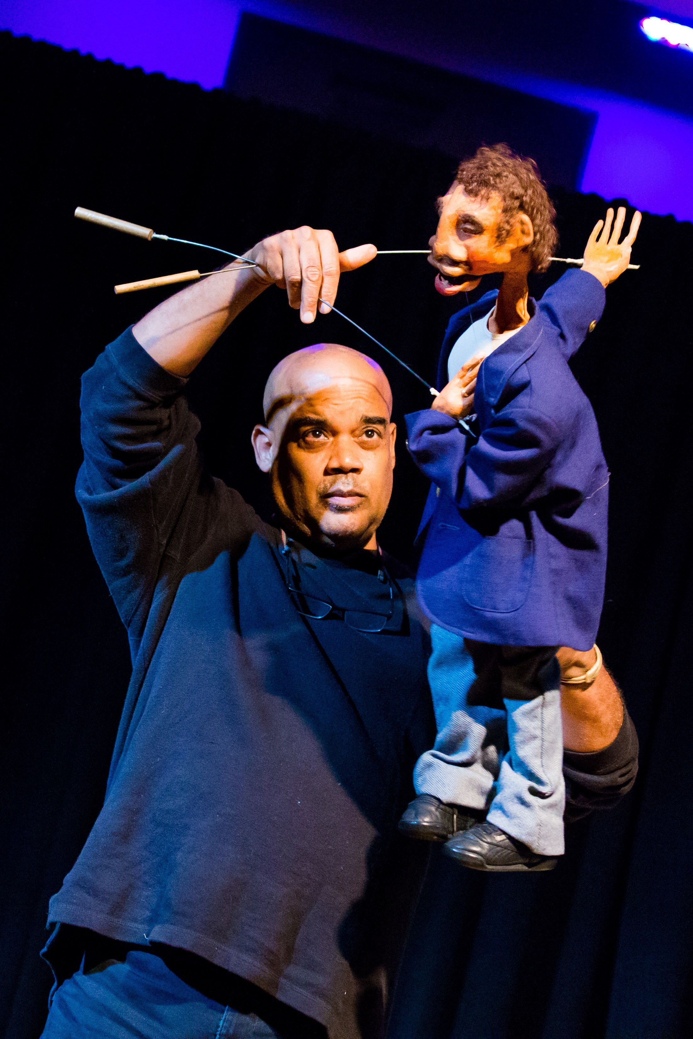 puppeteer manipulating puppet on stage