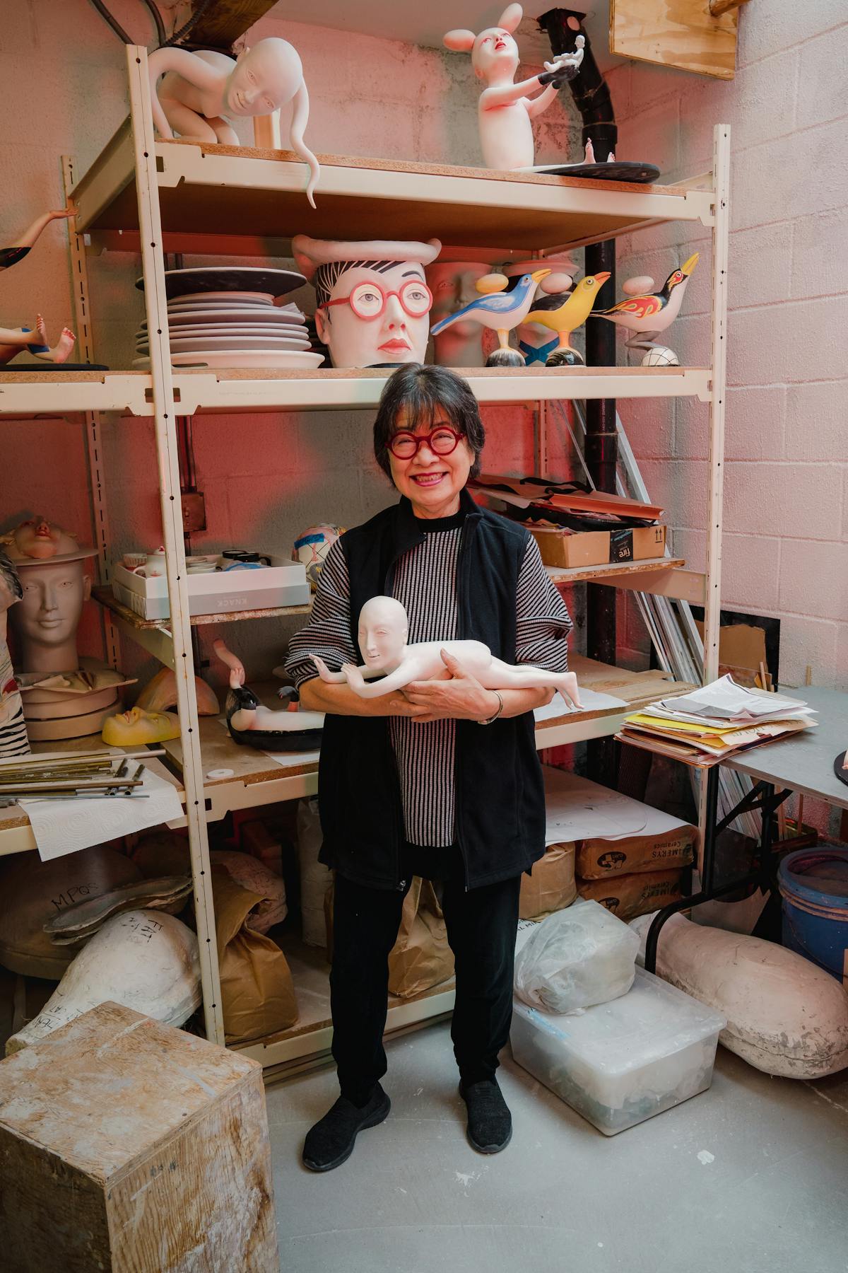 portrait of patti warashina in studio holding ceramic figure of a person