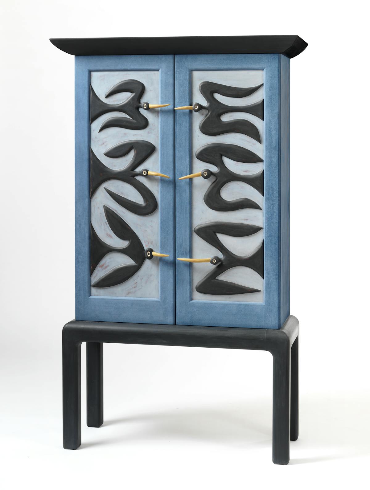 blue and black cabinet with bird motif with beaks providing door handles