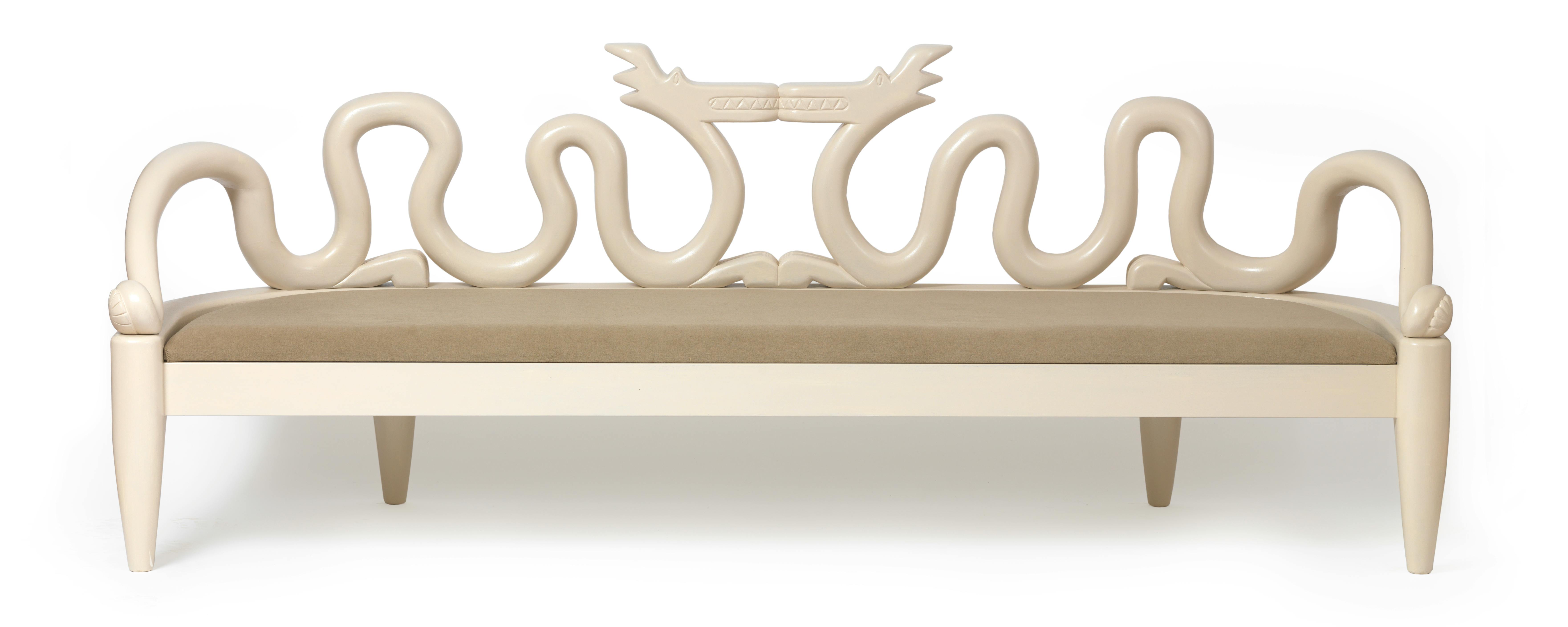 light tan carved wooden settee with dragon shaped back rest