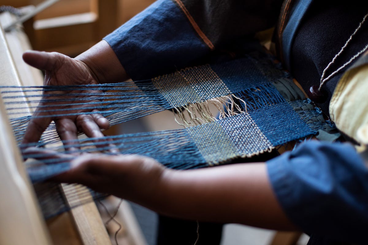 karen hamptons hands working on a blue weaving