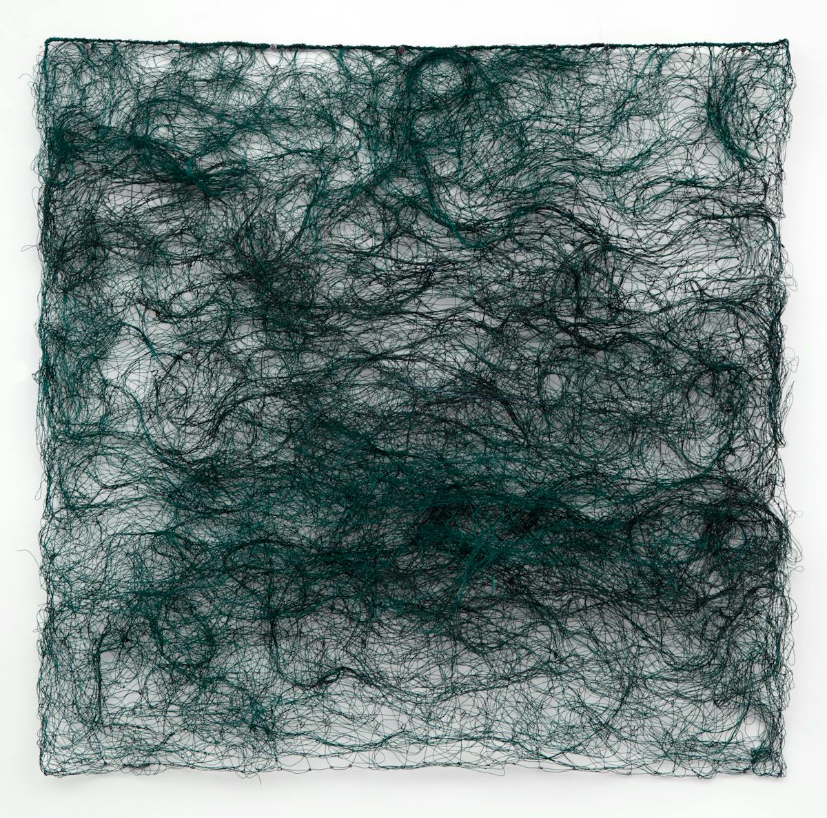 textile wall artwork in the form of a square of dark teal wool like fiber