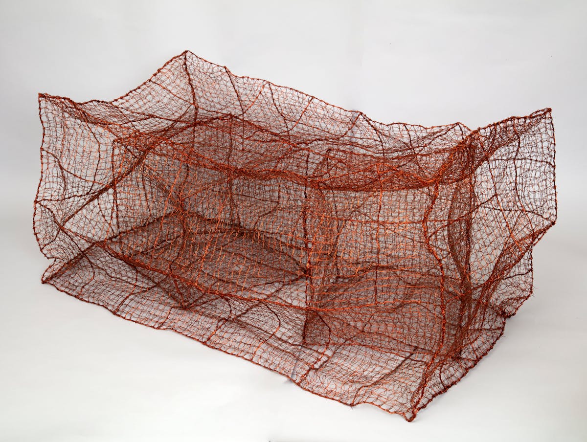 abstract textile sculpture with rectangular box made of maroon netlike material containing two similar smaller boxes