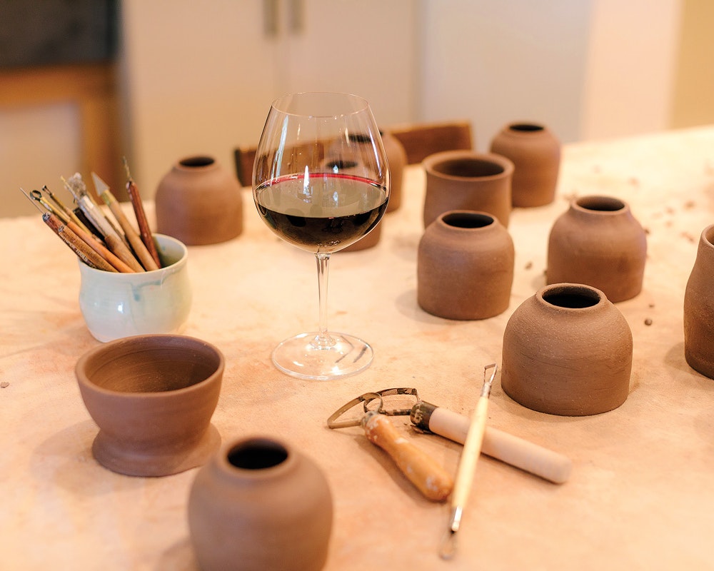 ceramics on a table with a glass of wine