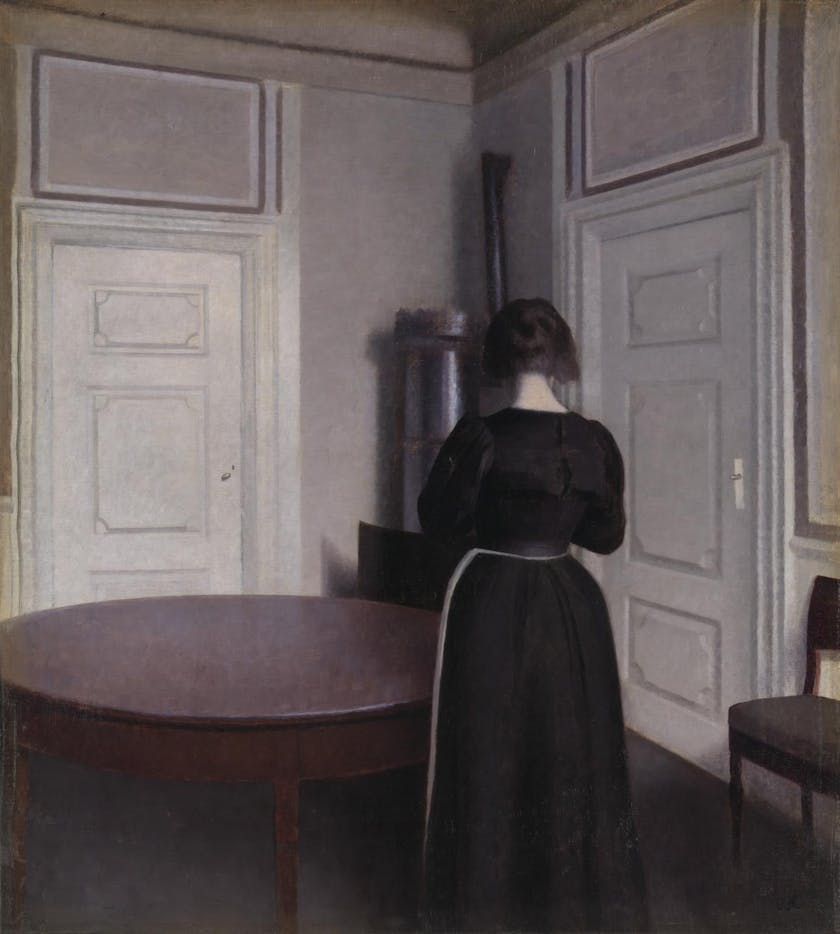painting of back of woman standing in a room beside a round table