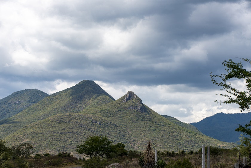 landscape photograph of a green mountain with cloudy sky