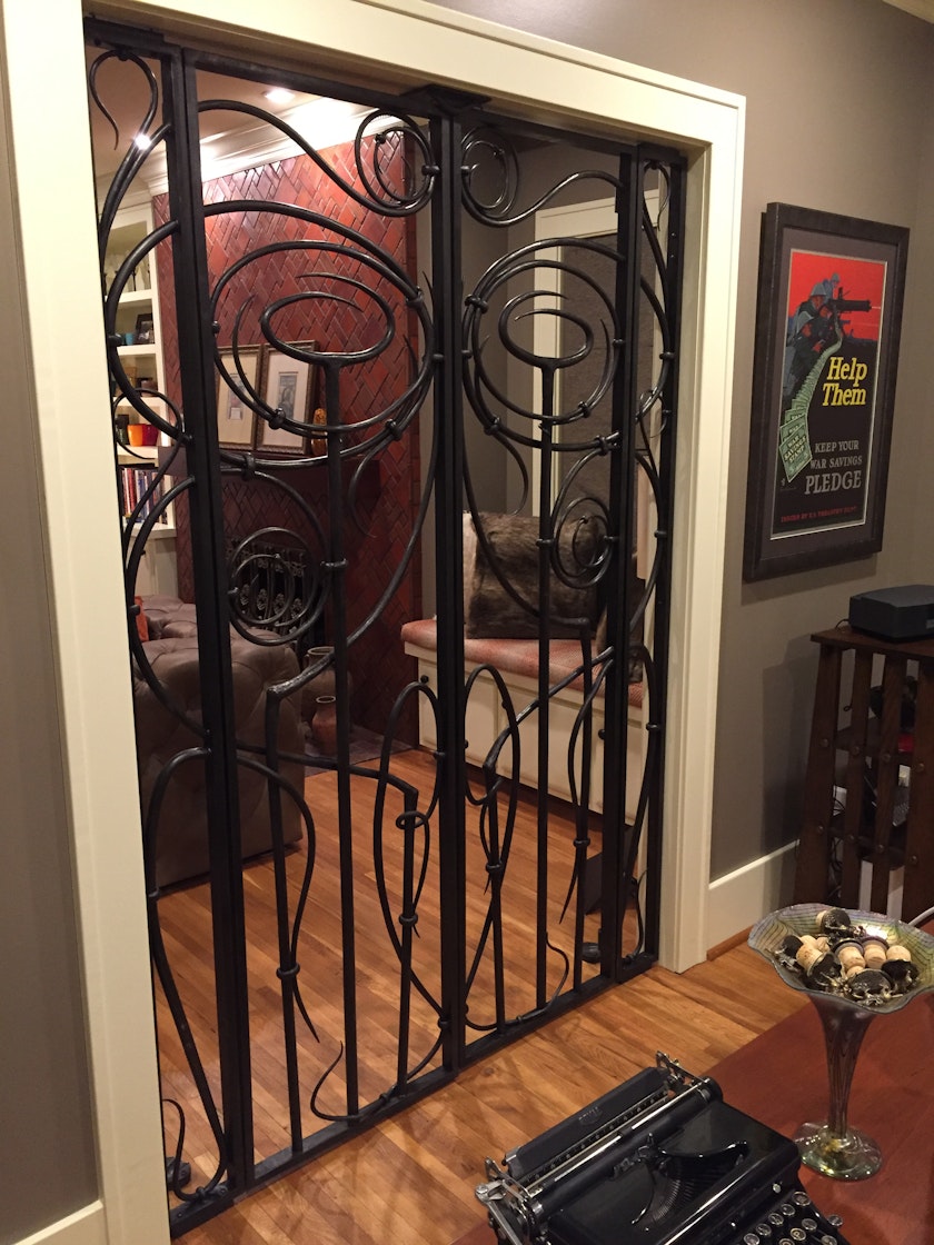 iron gate with swirling bars separating two rooms in a home