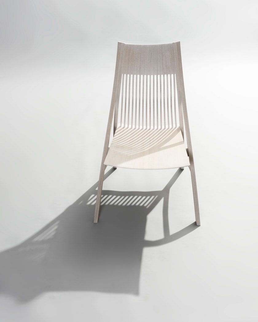 minimalist wooden chair pictured from above with dramatic shadow