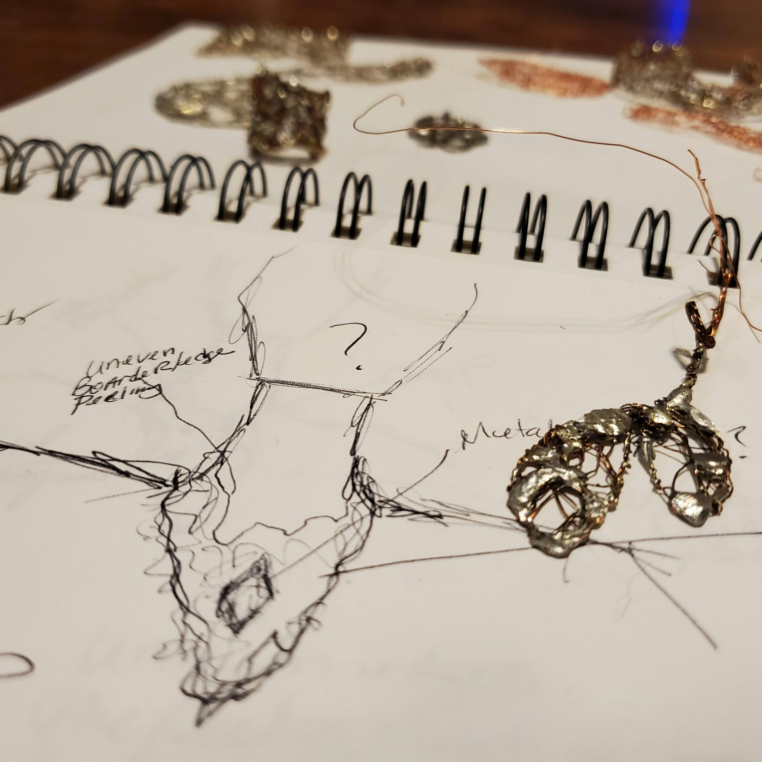 notepad with sketch of jewelry art concept
