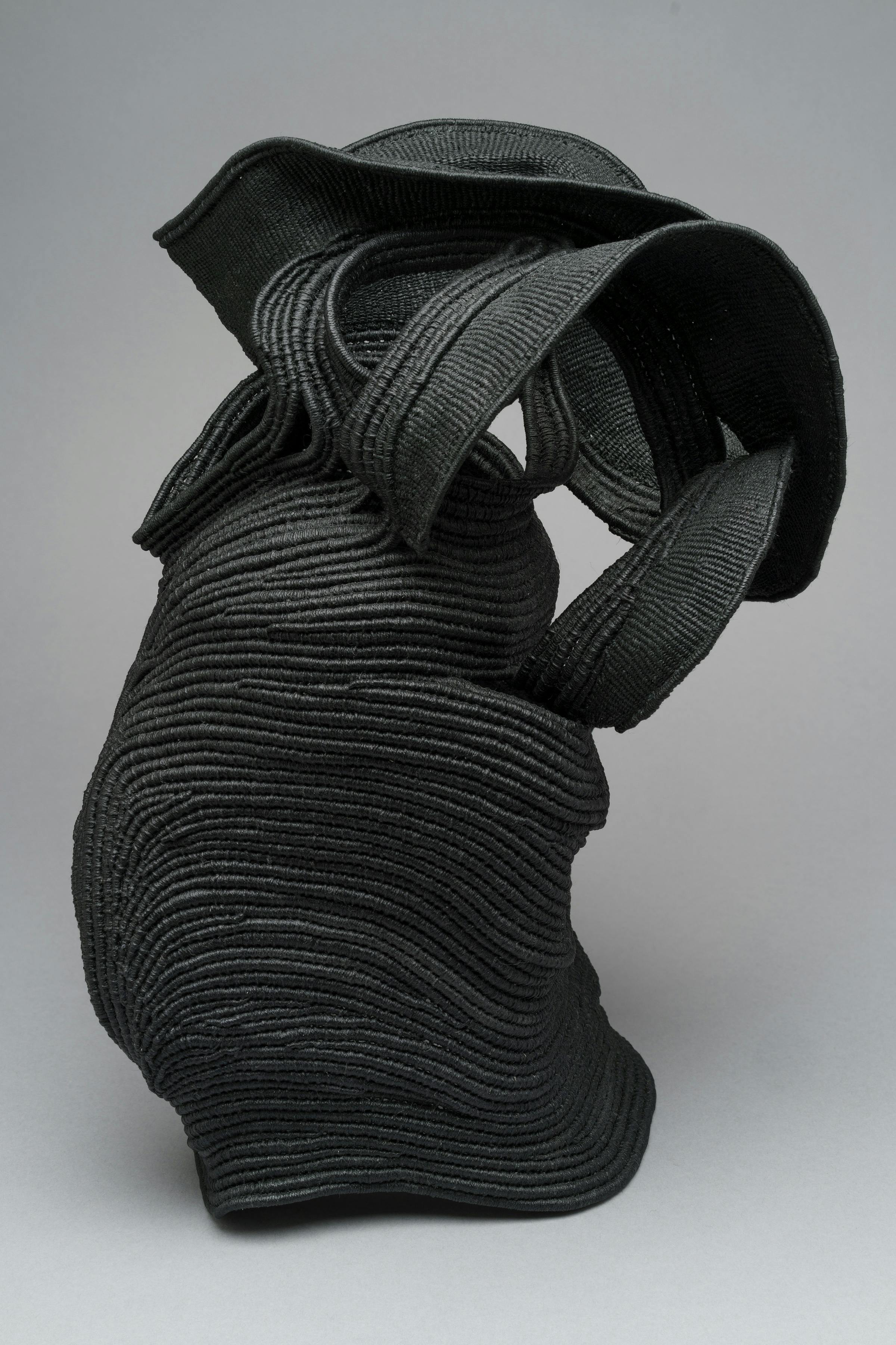 vessel-like sculpture made from coiled black rope