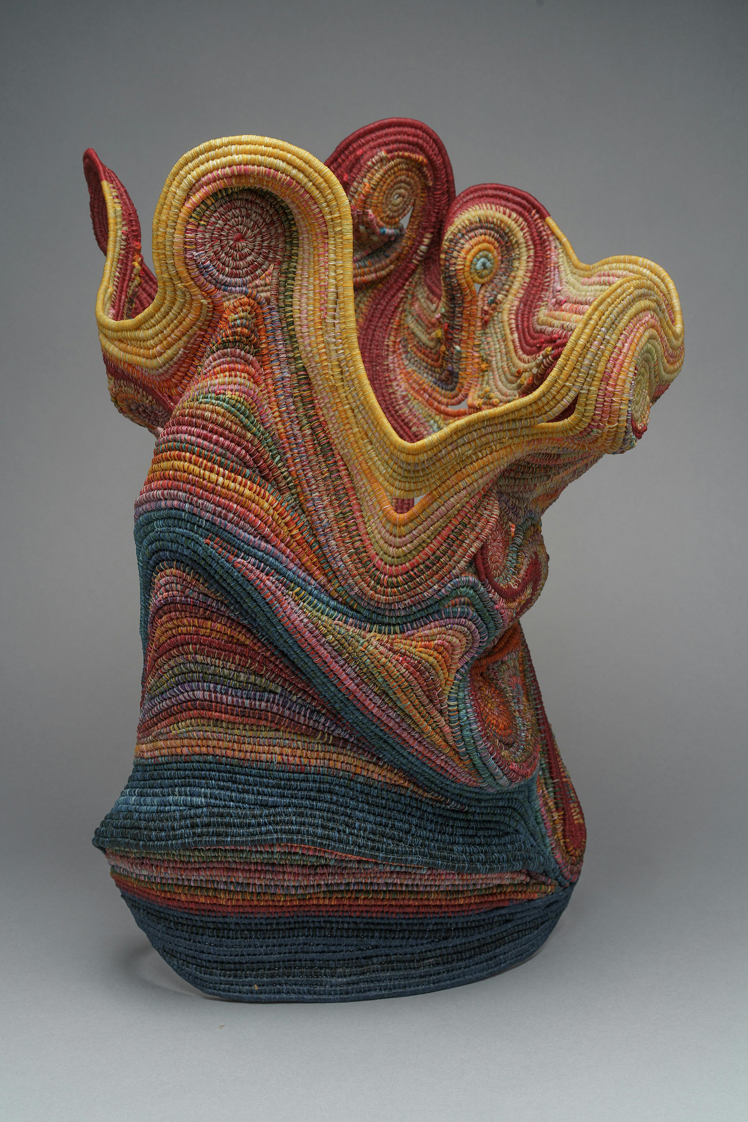 vessel-like sculpture made from coiled multi-colored rope