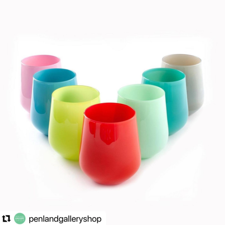 screenshot of an instagram post showing a set of opaque glass cups of various colors arranged in a v shape