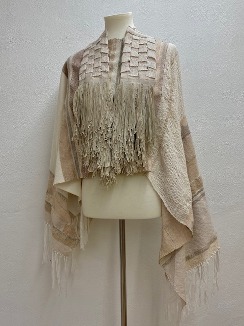 cream colored handwoven shawl displayed on a mannikin
