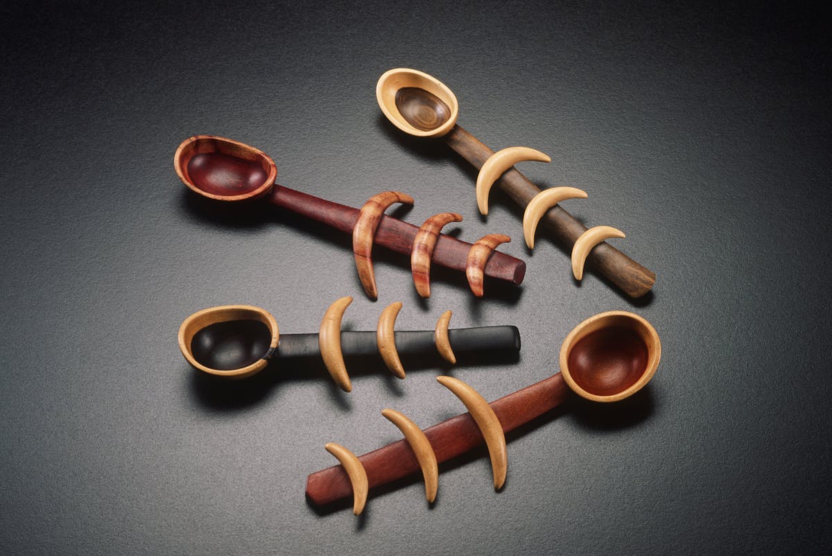 four handmade wooden spoons with moonlike shapes on the handles