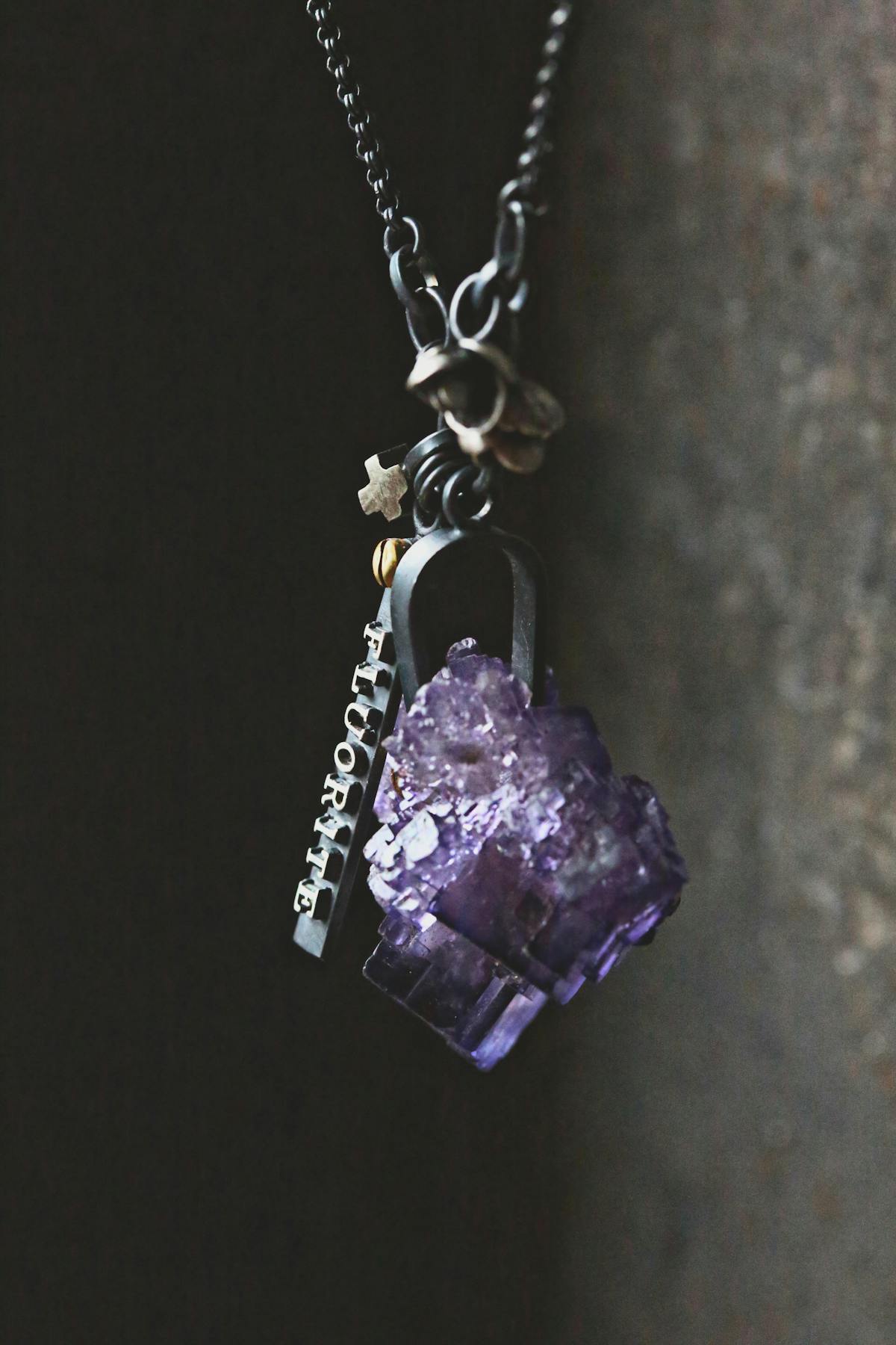 necklace with purple gemstone and various ornaments