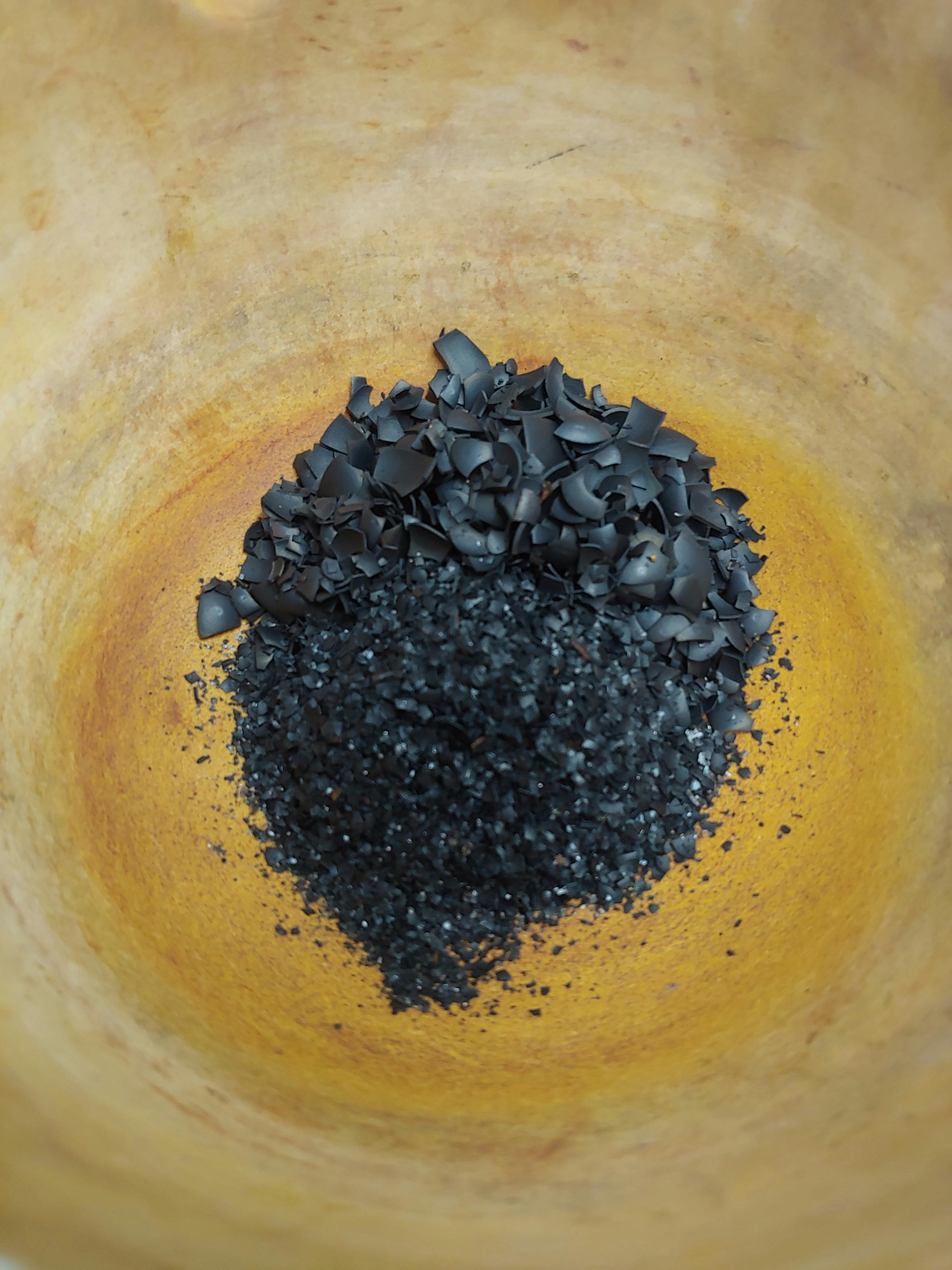 black crystals and powder in a mortar