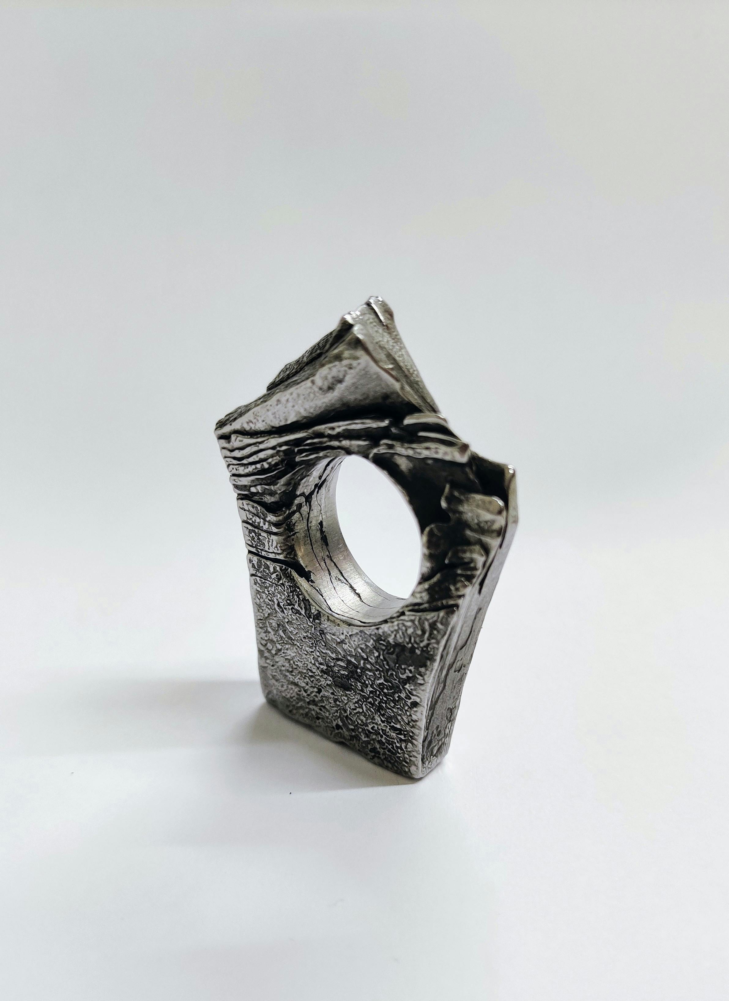 sculptural metal ring in pentagon shape with folded crags and textured surface