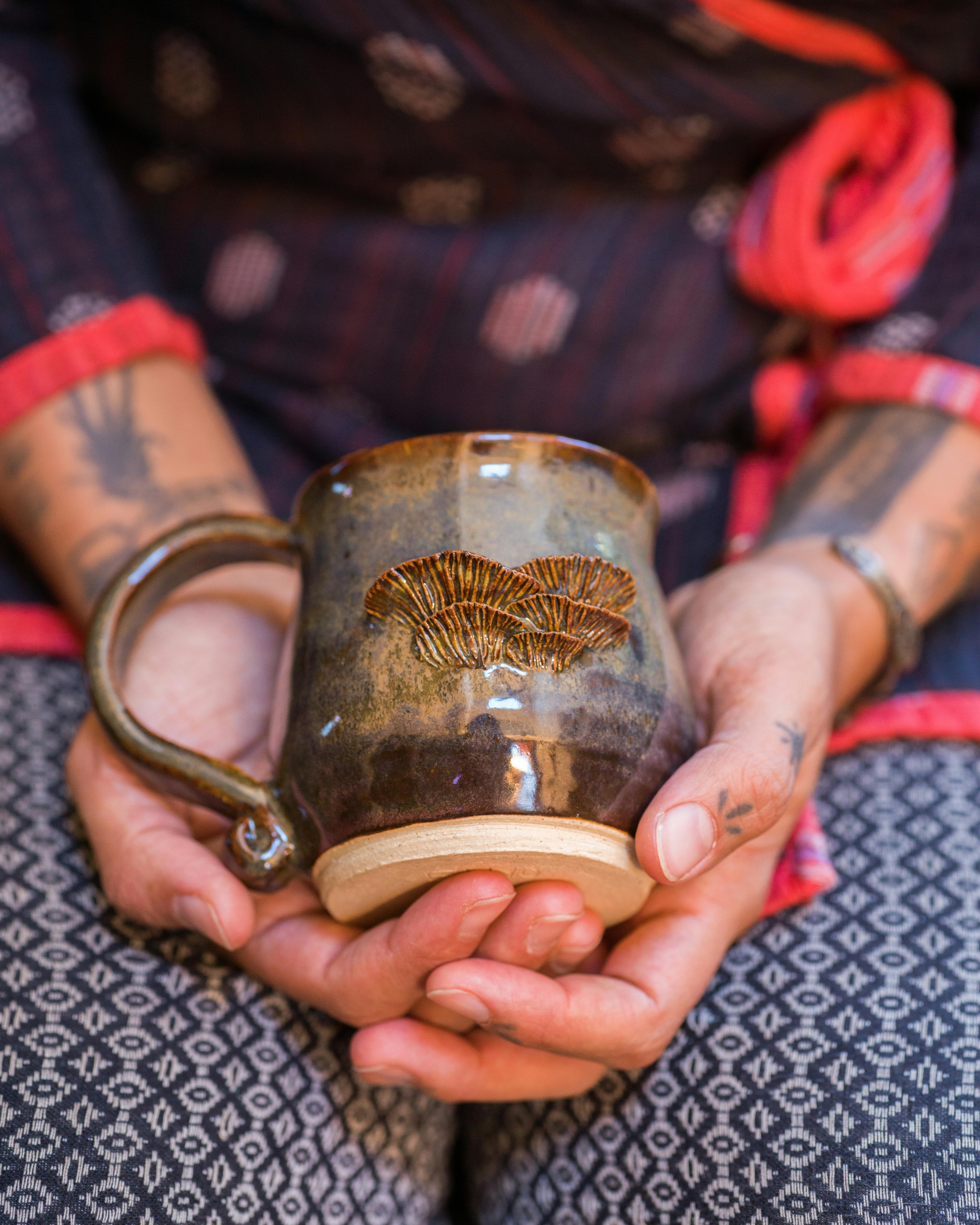 hands holding mug by enyo farabi