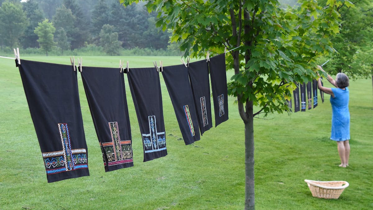 artist loriene pearson hanging embroidered textiles on clothes line to dry
