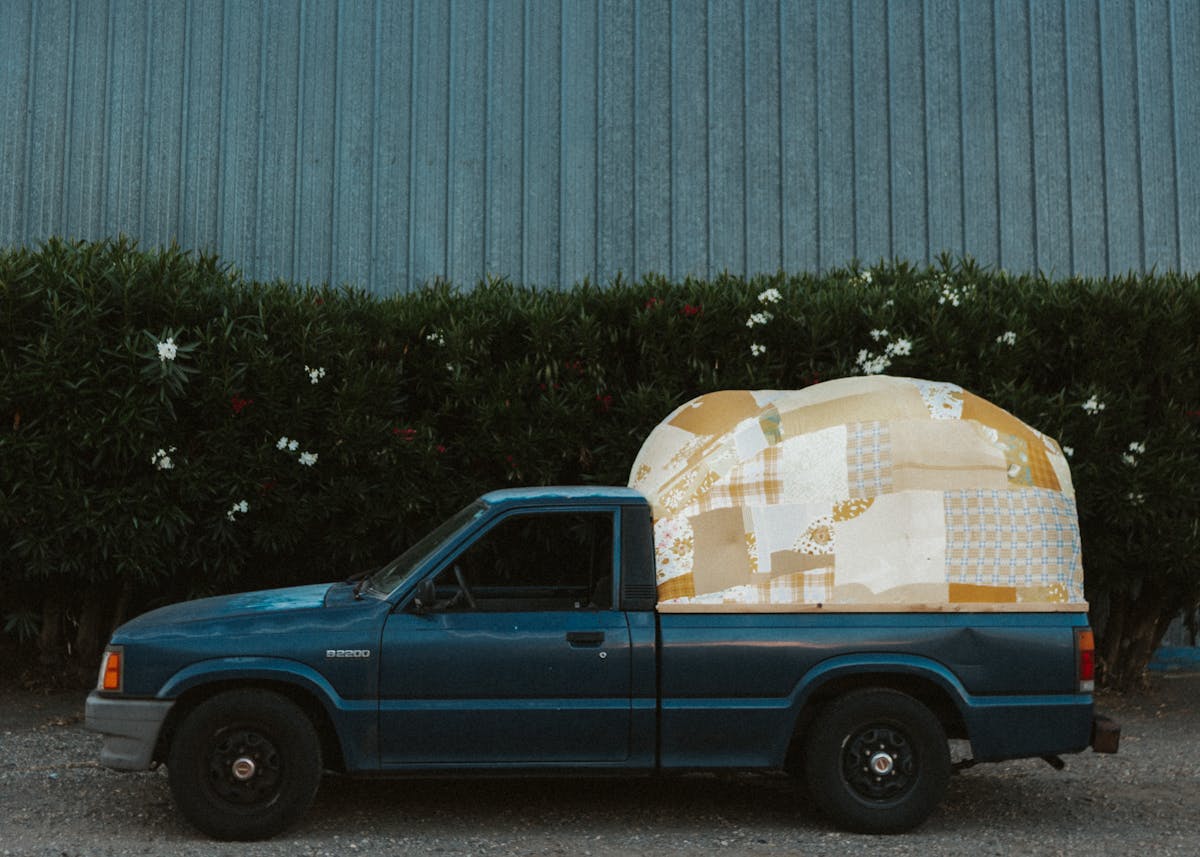 Blue pickup truck with patchwork canvas tent built onto back