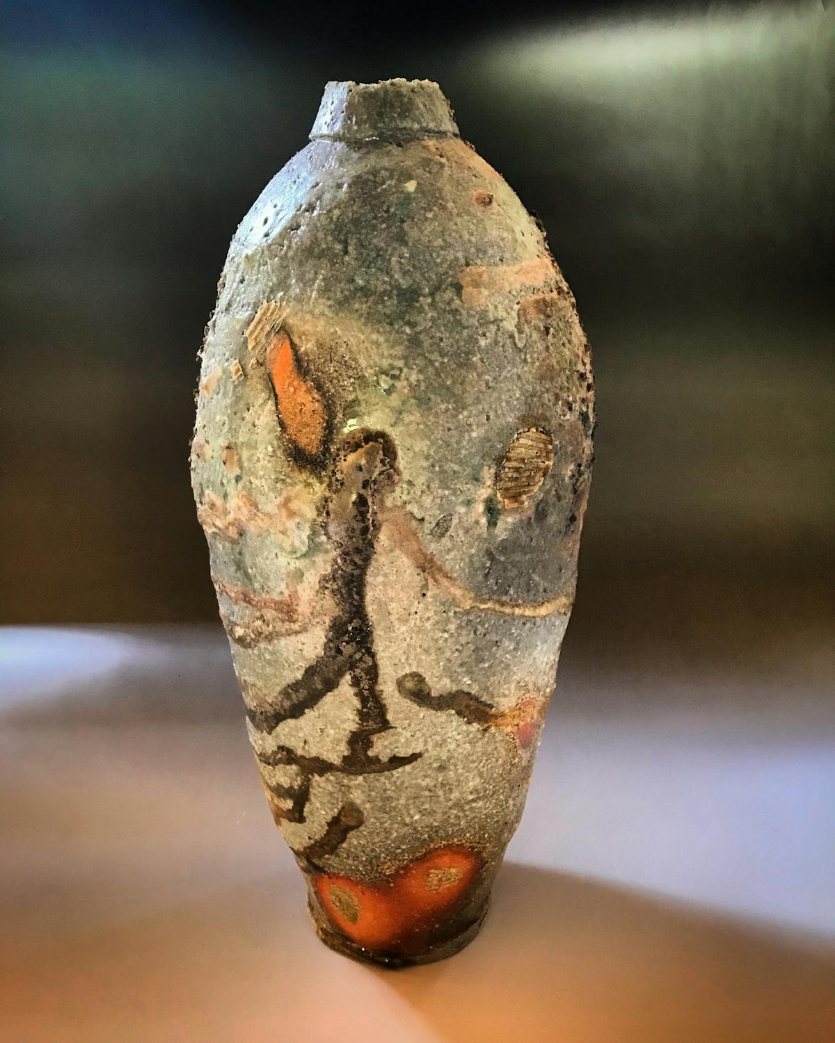 stoneware bottle with rough pocked texture and mottled coloration