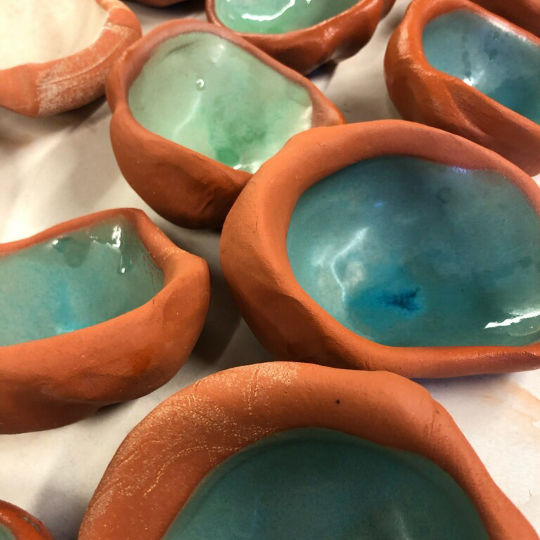 Variety of ceramic bowls with organic shapes and teal interior glaze