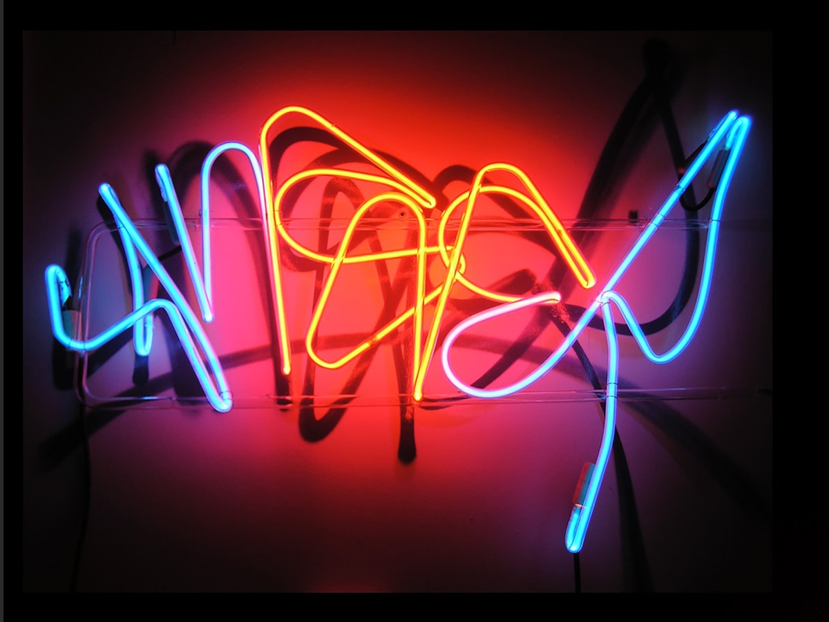 stylized word anser spelled out in neon tubing glowing blue and orange