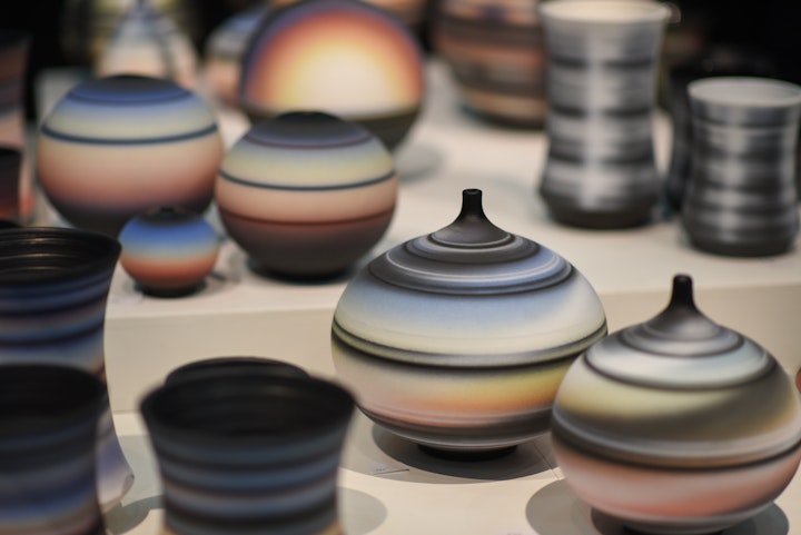 multicolored striped ceramic vessels on display